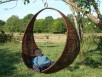 Petite balancelle d'osier tressé sur ossature métallique à suspendre dans le jardin pour les enfants...ou pour des potées végétales