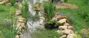 Aménagement des berges d'un cours d'eau créé de toutes pièces : pierres et végétaux mêlés